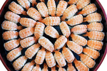 Top view of a lot of fresh shrimp sushi in a big round dish