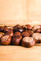 autumn brown chestnuts on an old wooden table