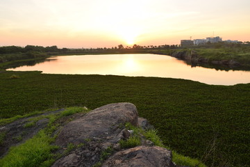 Fototapeta na wymiar sunset in lake with rock foreground