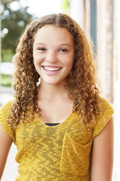 Portrait of happy teenage girl standing outdoors