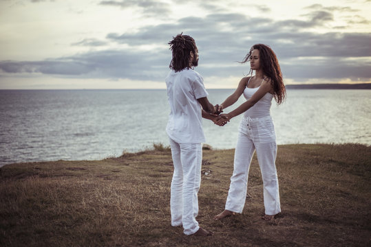 Couple holding hands while standing on field