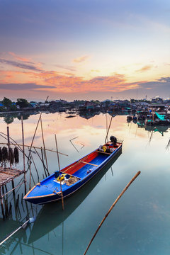 Fishing boats in harbor with sunrise