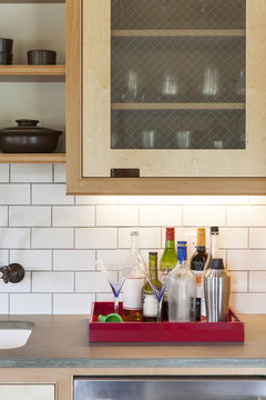 Bottles and glasses in tray on kitchen counter