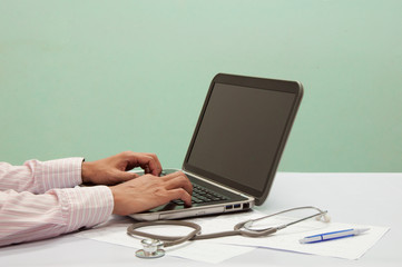 Doctor working with computer at desk in the hospital