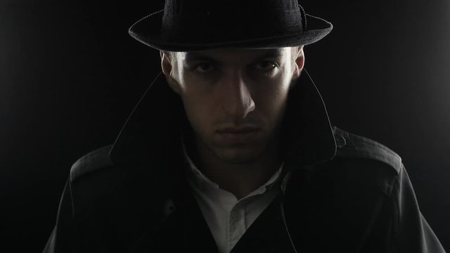 Portrait of a gangster in a hat and a black cloak