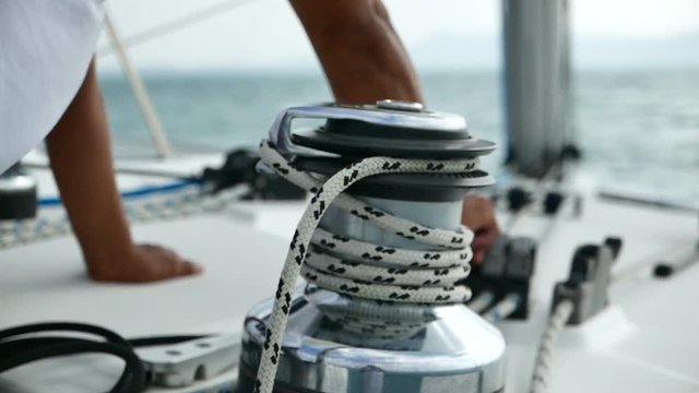 Man sailing pulling ropes.