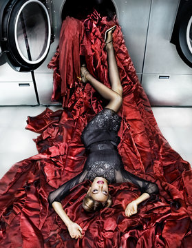 Woman Wearing Black Dress Falling From Washing Machine With Red Fabric 