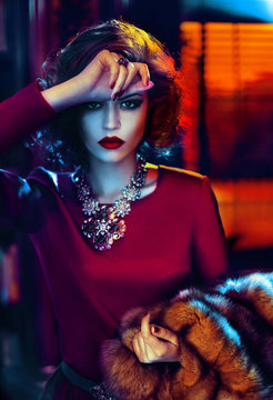 Woman in red dress holding fur, portrait