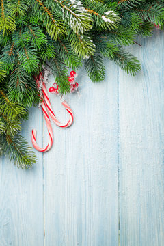 Candy cane and christmas tree on wooden table