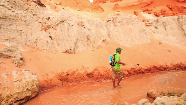 Tourist Makes Selfie against Red Hills of Fairy Stream