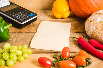 cash register and blank paper on the table with vegetables