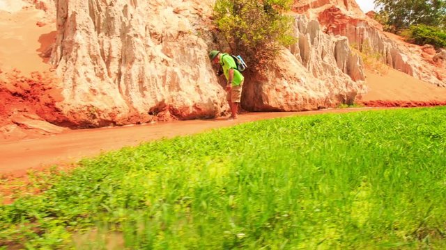 Tourist Walks in Fairy-Stream Examines Bottom by Green Grass