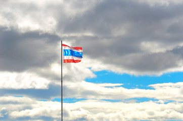Thailand flag on the sky with white clouds.