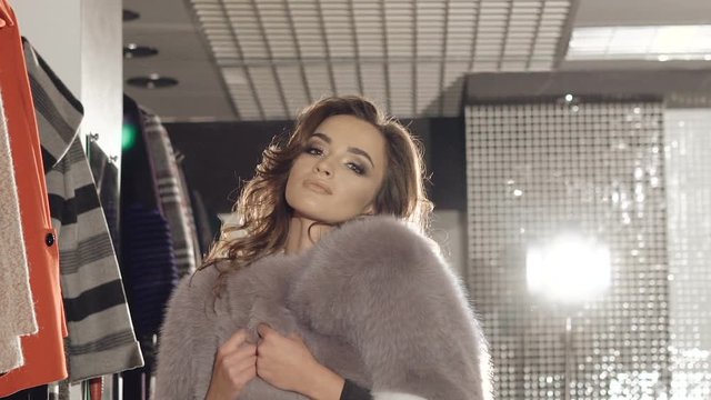 Sexy woman flirting seductive in rich fur coat. Slowly