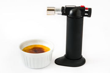 Traditional French creme brulee dessert and cooking blowtorch

