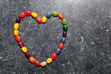 Herz aus Jellybeans auf einer Steinplatte
