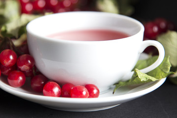 Background of delicious tea with red viburnum berries