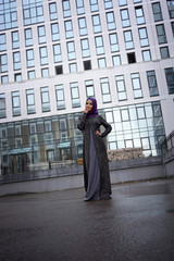 Fototapeta na wymiar Young Muslim woman in oriental dress on a background of a modern building