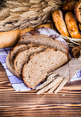 Assortment of baked bread on wooden table background