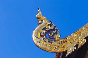 Fototapeta na wymiar Beautiful Golden Thai Lanna Architecture: Naga wood carved at Chapel Roof of Wat Inthakhin Sadue Muang, Chiangmai, THAILAND.
