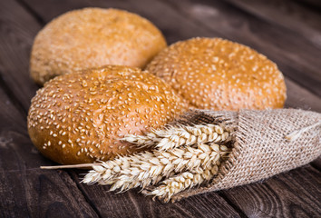 Assortment of baked bread on wooden table background