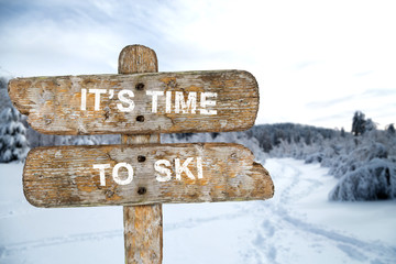 Old wooden signpost with the inscription. It's time to ski. In t