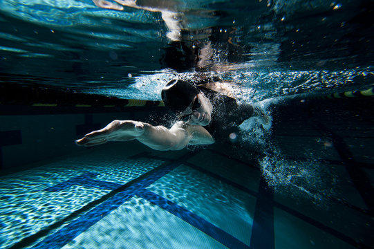 Woman swimming underwater in pool 