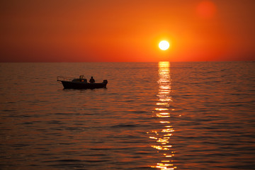Fisherman in a boat during sunset