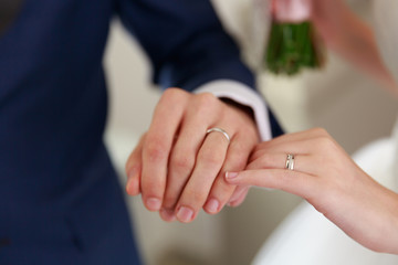 Obraz na płótnie Canvas bride and groom hands wearing weddning rings