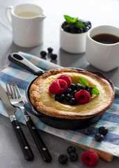 Breakfast with Dutch Baby pancake, served with fresh berries and mint
