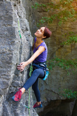 The girl climbs the rock.