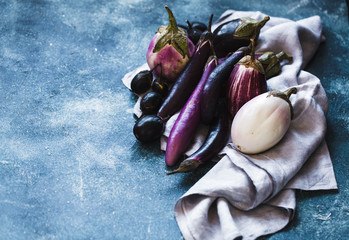 Colorful purple eggplants over linen napkin. Copy space. 