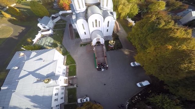 Newlyweds gather outside Orthodox church aerial view