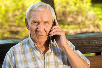 Senior man with phone. Surprised face of old guy. I finally heard the truth. Uncovering the secret.