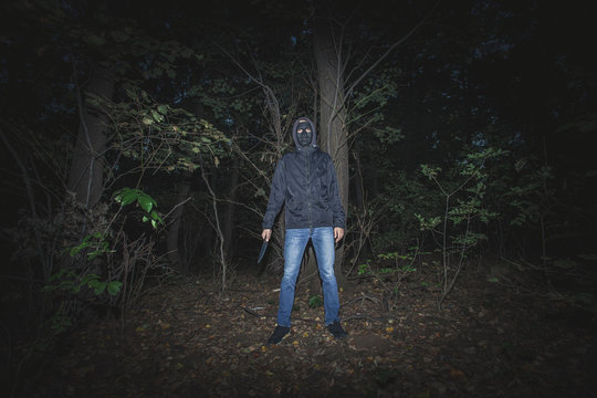 man with mask and knife in the wood