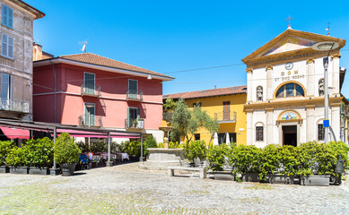 Piazza San Rocco with restaurant, fountain and church in the historic center of Verbania Intra, Italy 