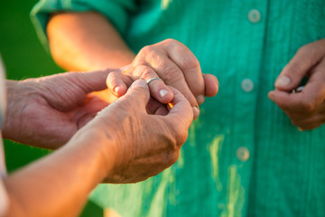 Man putting ring on lady. Hands of a senior couple. Fill your heart with love. Have no fear.