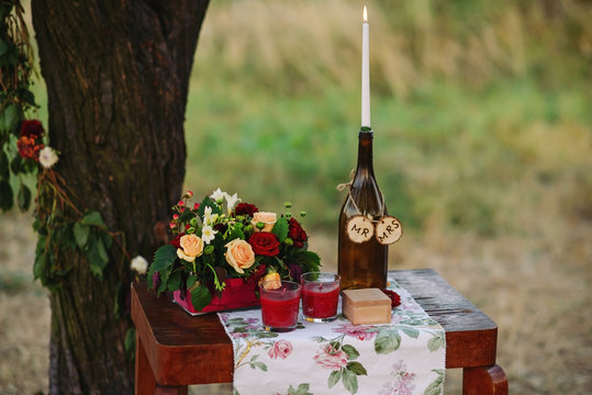 Ceremony table with a bouquet of flowers, candles and box for wedding rings