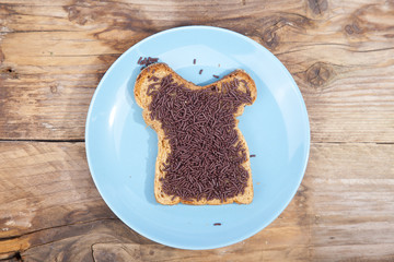 Typical Dutch bread with chocolate hagelslag on wooden background