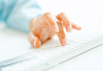 Woman office worker typing on the keyboard