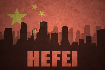 abstract silhouette of the city with text Hefei at the vintage chinese flag background