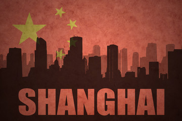 abstract silhouette of the city with text Shanghai at the vintage chinese flag background