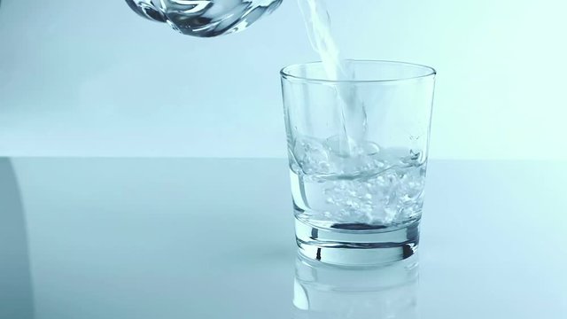 filling a glass with water through bottle, nutrition and health-care concept