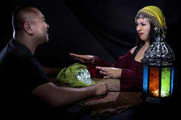 Skeptical man arguing with a female con artist fortune teller or spirit medium about fraud