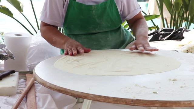 Woman making pancakes, traditional Turkish food (gozleme)
