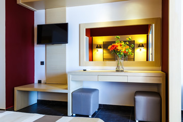 Luxury modern hotel room interior details. mirror and vase of flowers on table