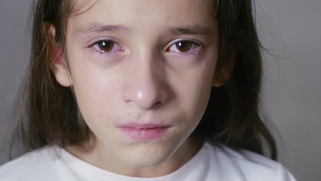 little girl crying with tears rolling down her cheeks