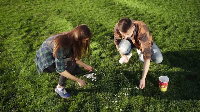 Woman presents popcorn to her boyfriend and they start eating
