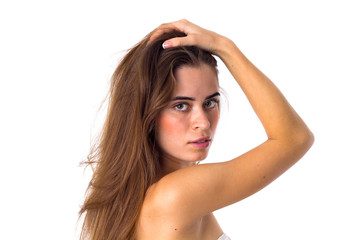 Fototapeta premium Woman standing sidewise and fixing hair