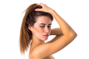 Fototapeta premium Woman standing sidewise and fixing hair